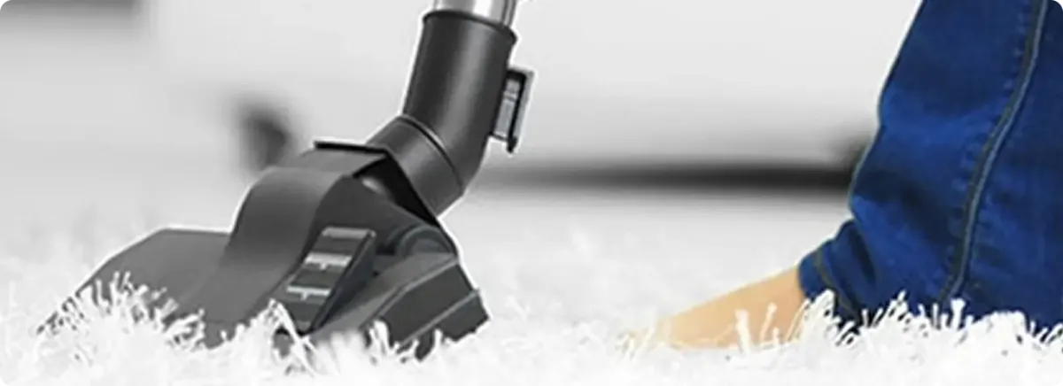 Close-up of a professional vacuuming a white carpet in Sun City.